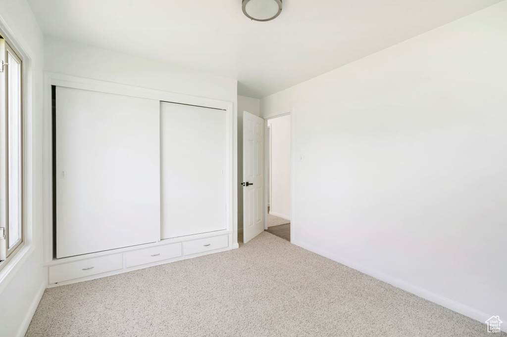 Unfurnished bedroom featuring carpet and a closet