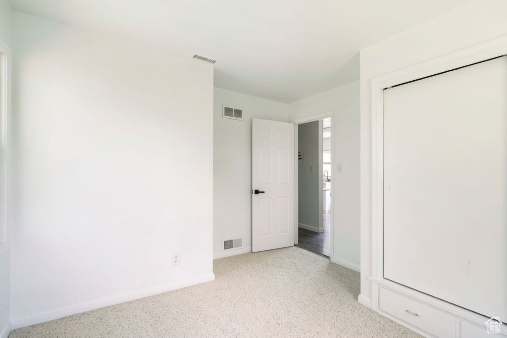 Unfurnished bedroom with light colored carpet