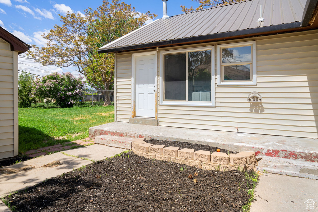 Doorway to property with a lawn