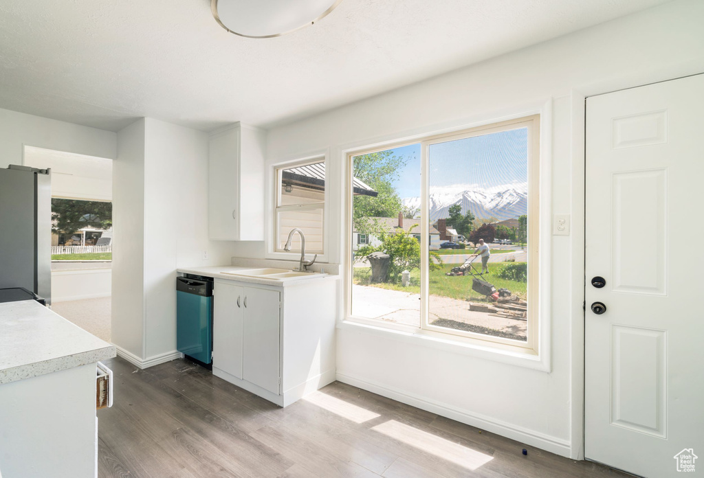 Kitchen featuring stainless steel appliances, white cabinetry, and plenty of natural light