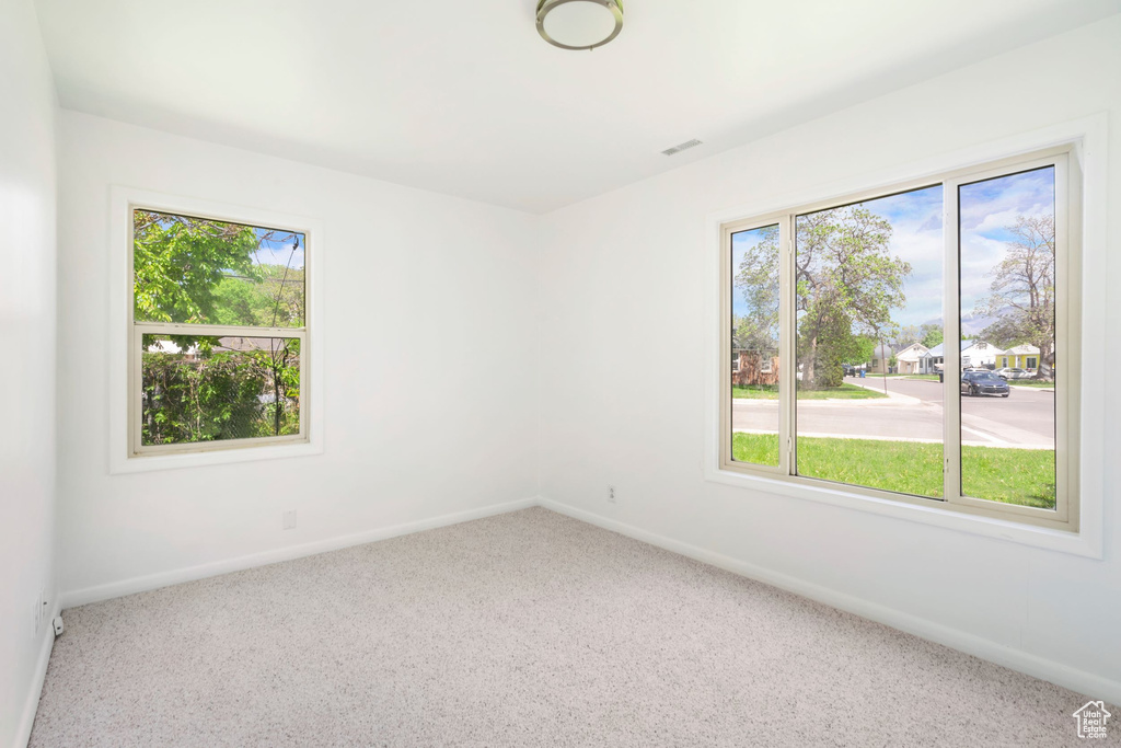 Carpeted empty room with a wealth of natural light