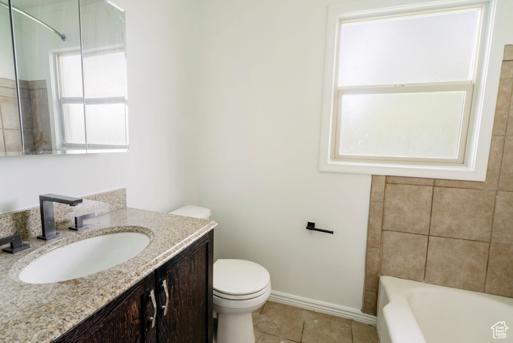 Full bathroom featuring tile floors, vanity with extensive cabinet space, shower / bathing tub combination, and toilet