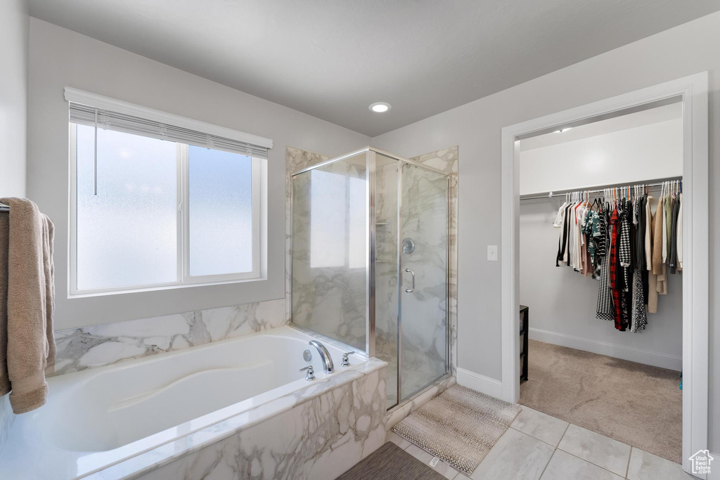 Bathroom with tile flooring and independent shower and bath