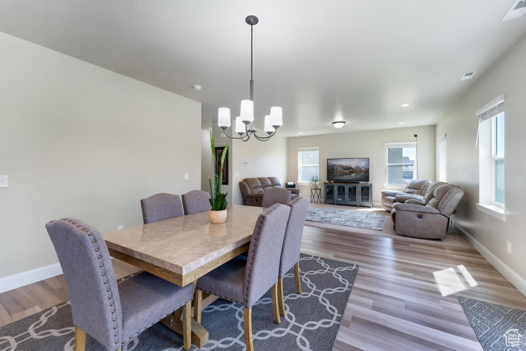 Dining area with a notable chandelier and hardwood / wood-style flooring