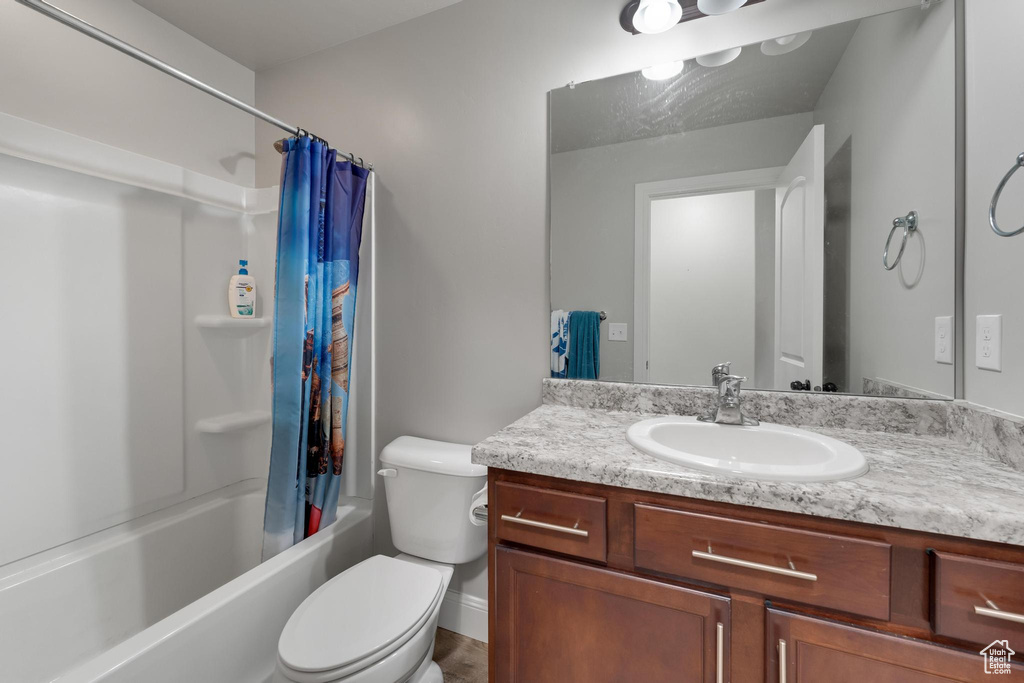 Full bathroom with shower / bath combination with curtain, vanity, and toilet