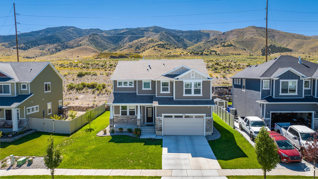 View of front facade with a front yard, a garage, and a mountain view