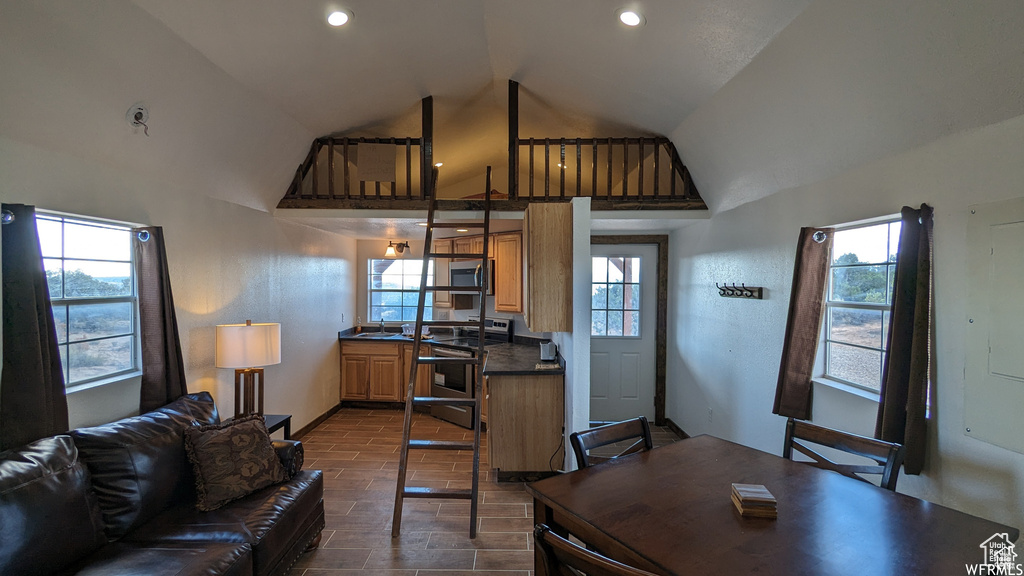 Living room featuring plenty of natural light, a towering ceiling, and sink