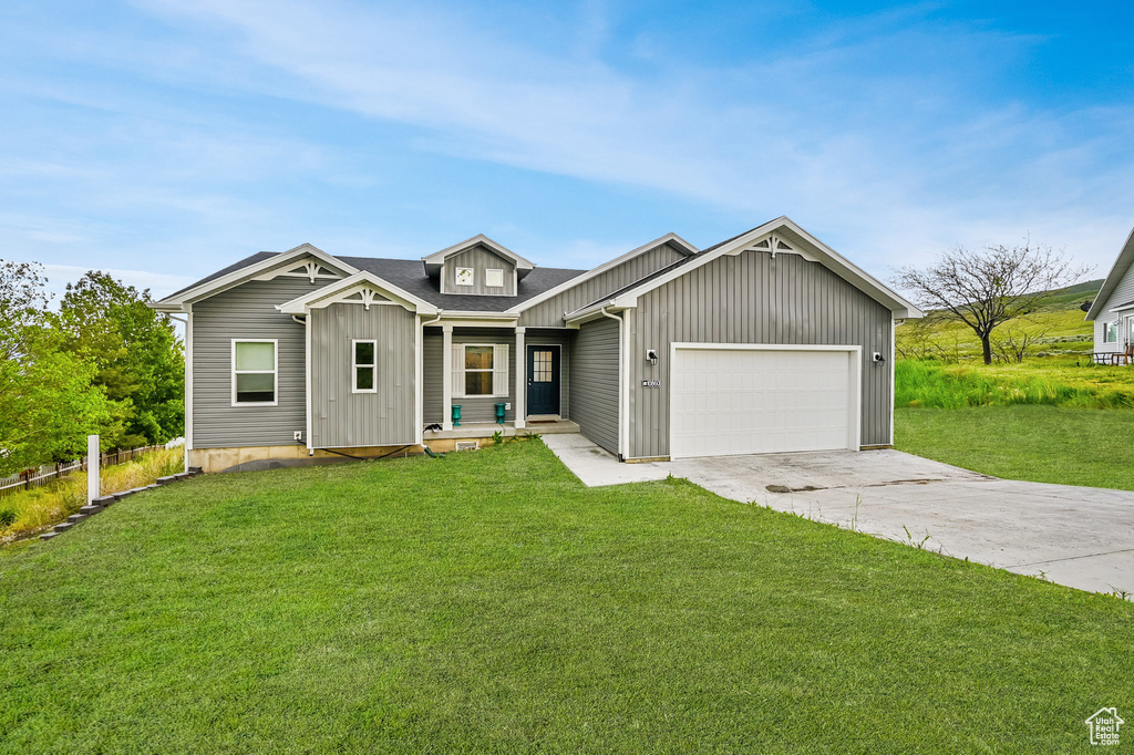 View of front of property featuring a garage and a front yard