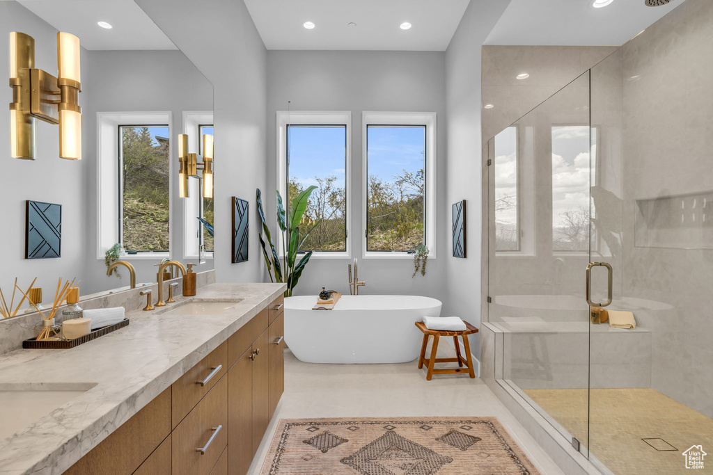 Bathroom with double vanity, plus walk in shower, and tile patterned flooring