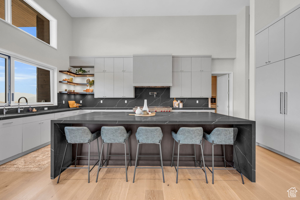 Kitchen with light hardwood / wood-style floors, backsplash, and a kitchen island