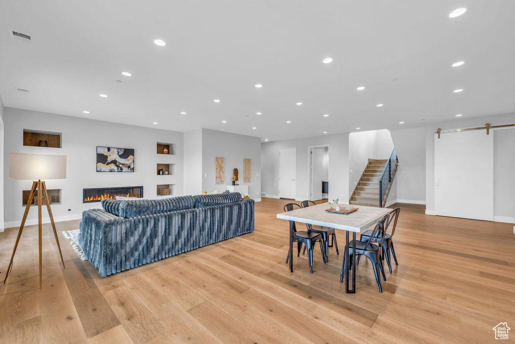 Dining area with a barn door and light wood-type flooring