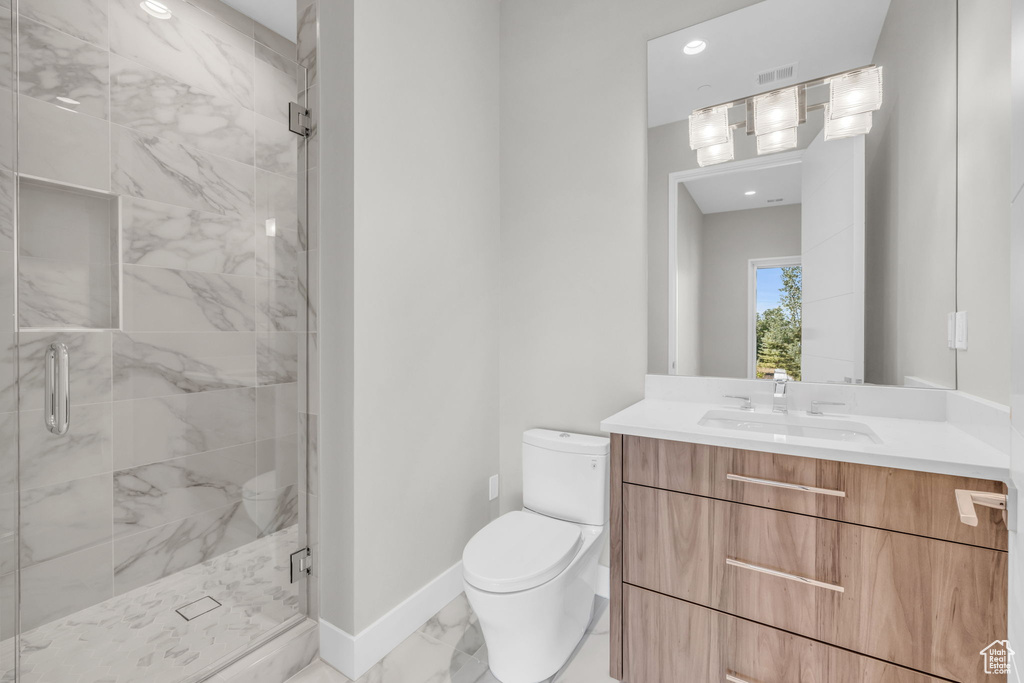 Bathroom with walk in shower, tile patterned floors, toilet, and vanity