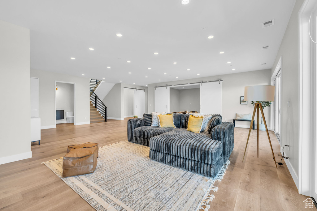 Living room featuring light wood-type flooring and a barn door