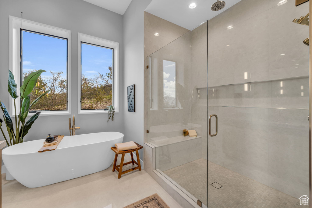 Bathroom featuring tile patterned floors, shower with separate bathtub, and a healthy amount of sunlight