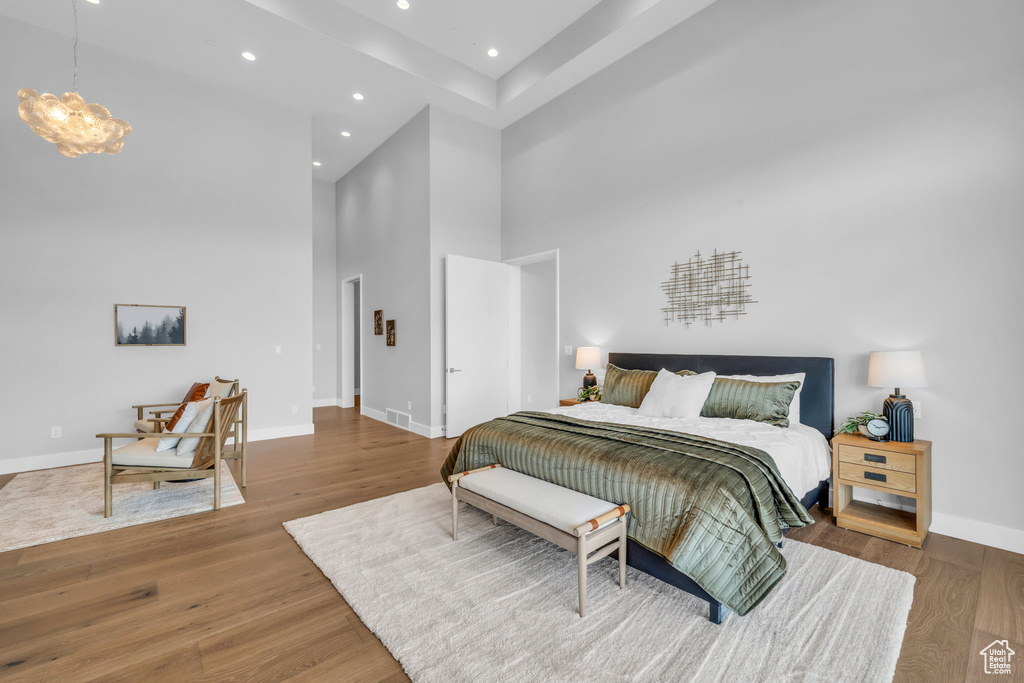 Bedroom with wood-type flooring and a high ceiling