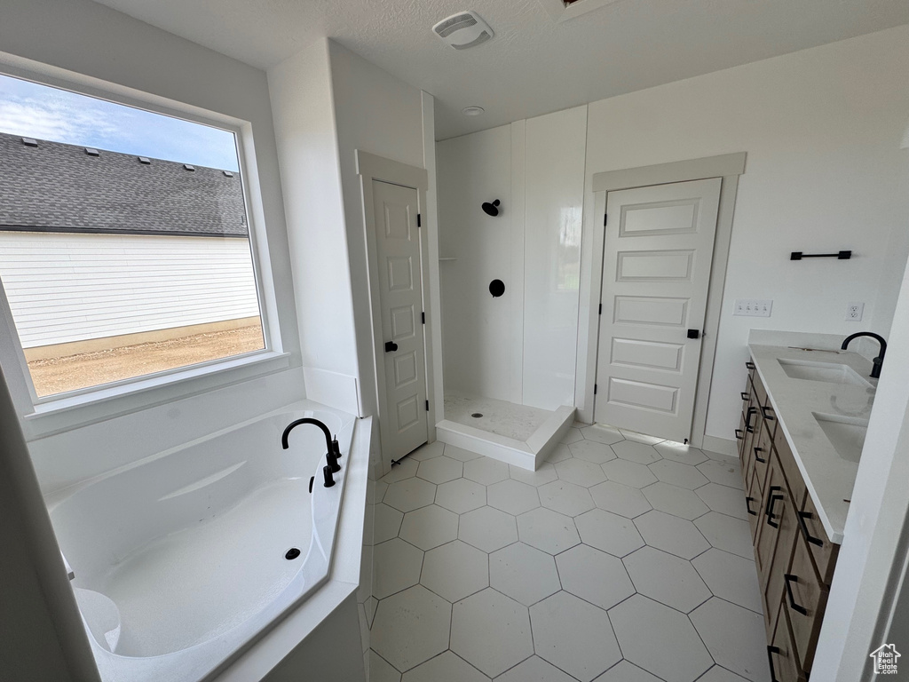 Bathroom with vanity, shower with separate bathtub, and tile patterned flooring