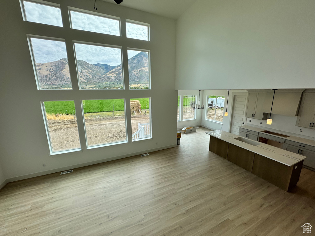 Kitchen featuring a mountain view, light wood-type flooring, and a high ceiling