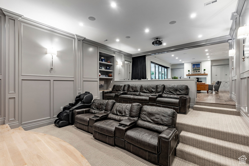 Home theater room with built in shelves and light hardwood / wood-style flooring