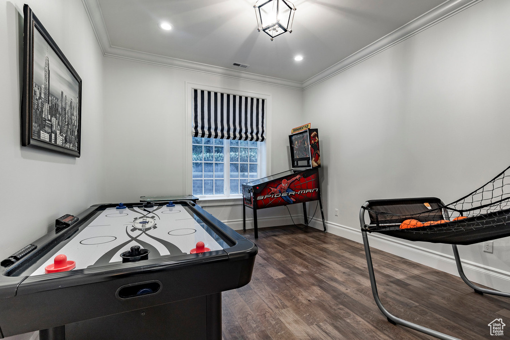 Recreation room featuring ornamental molding and dark hardwood / wood-style flooring