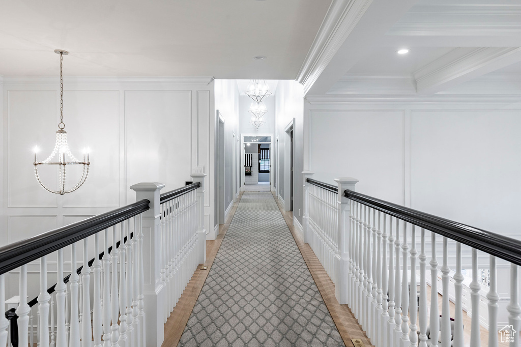 Hall with a notable chandelier and ornamental molding