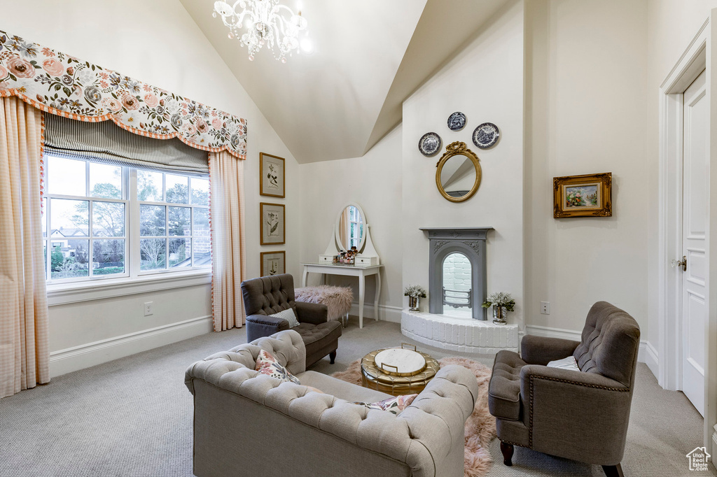 Carpeted living room featuring a notable chandelier and high vaulted ceiling