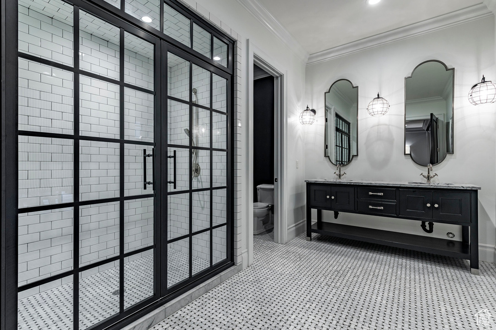 Bathroom featuring crown molding, tile flooring, double sink vanity, and toilet