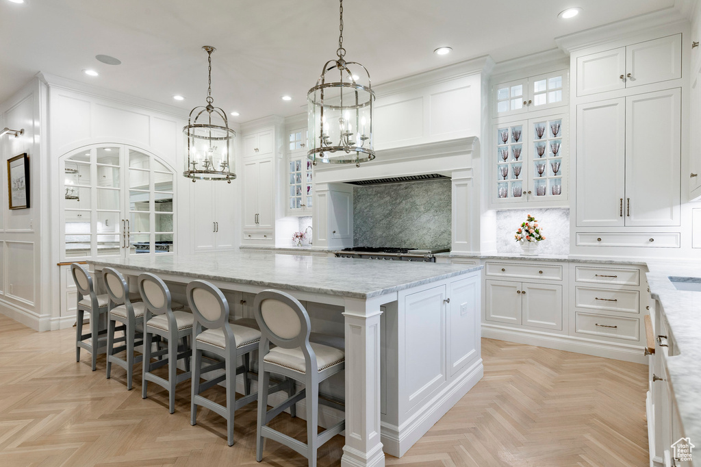 Kitchen featuring a kitchen island, light parquet flooring, and white cabinetry