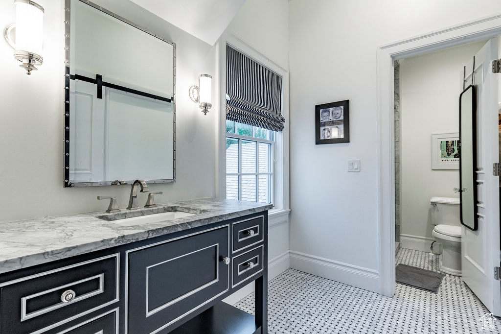 Bathroom featuring tile floors, vanity, and toilet