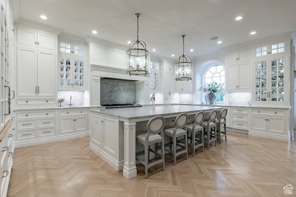 Kitchen featuring light parquet flooring, white cabinetry, and backsplash