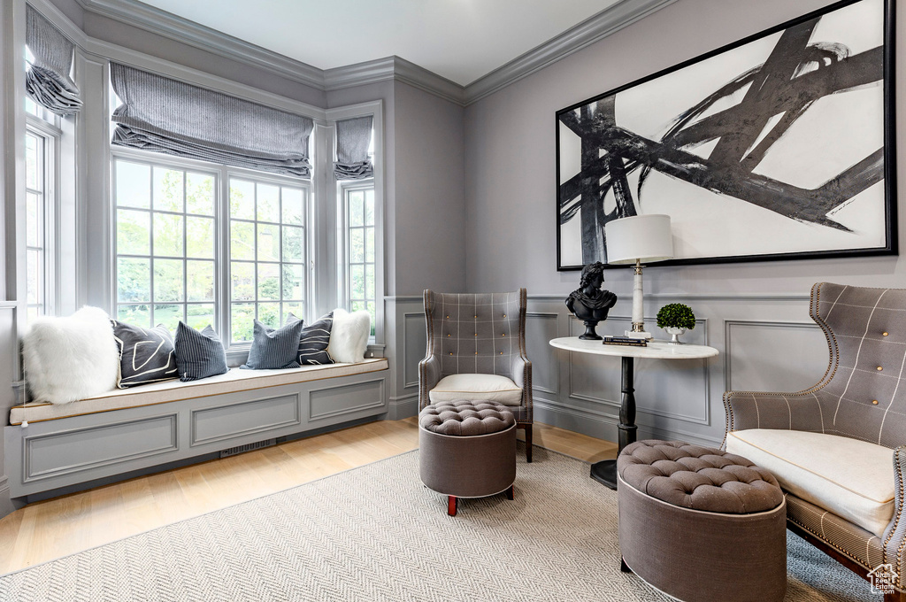 Living area with hardwood / wood-style flooring and ornamental molding