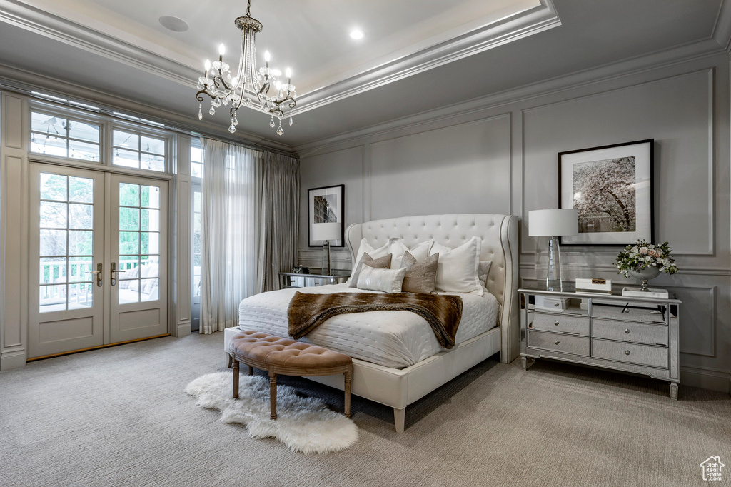 Carpeted bedroom with crown molding, french doors, an inviting chandelier, access to outside, and a raised ceiling