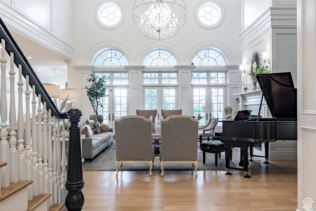 Living room with a high ceiling, a chandelier, and wood-type flooring