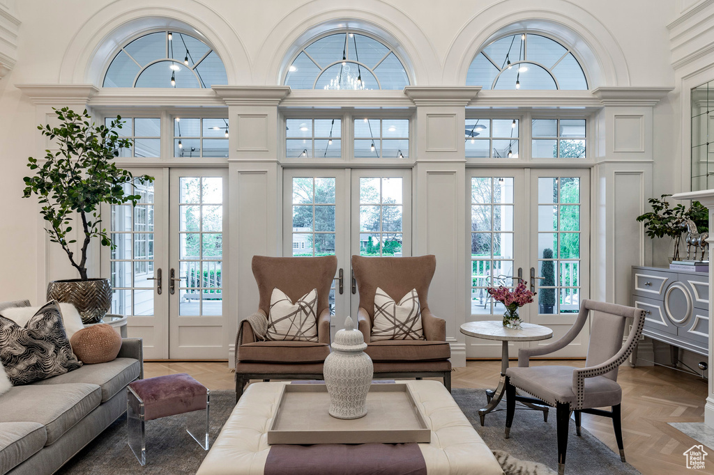 Living room with a high ceiling, french doors, and parquet floors