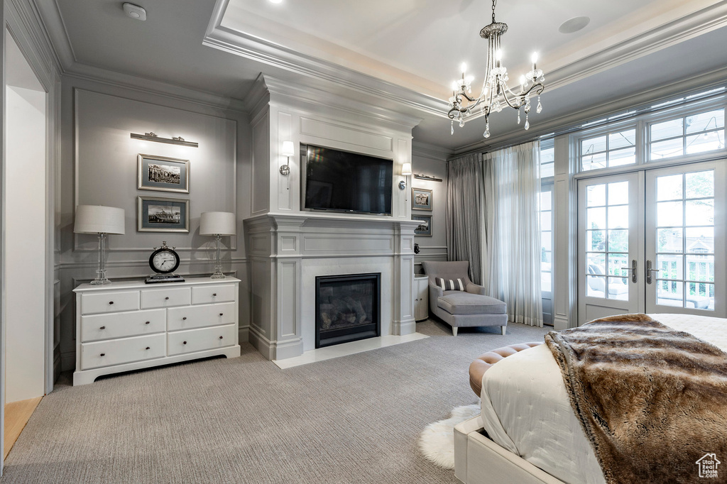 Carpeted bedroom featuring french doors, a notable chandelier, a raised ceiling, access to outside, and ornamental molding