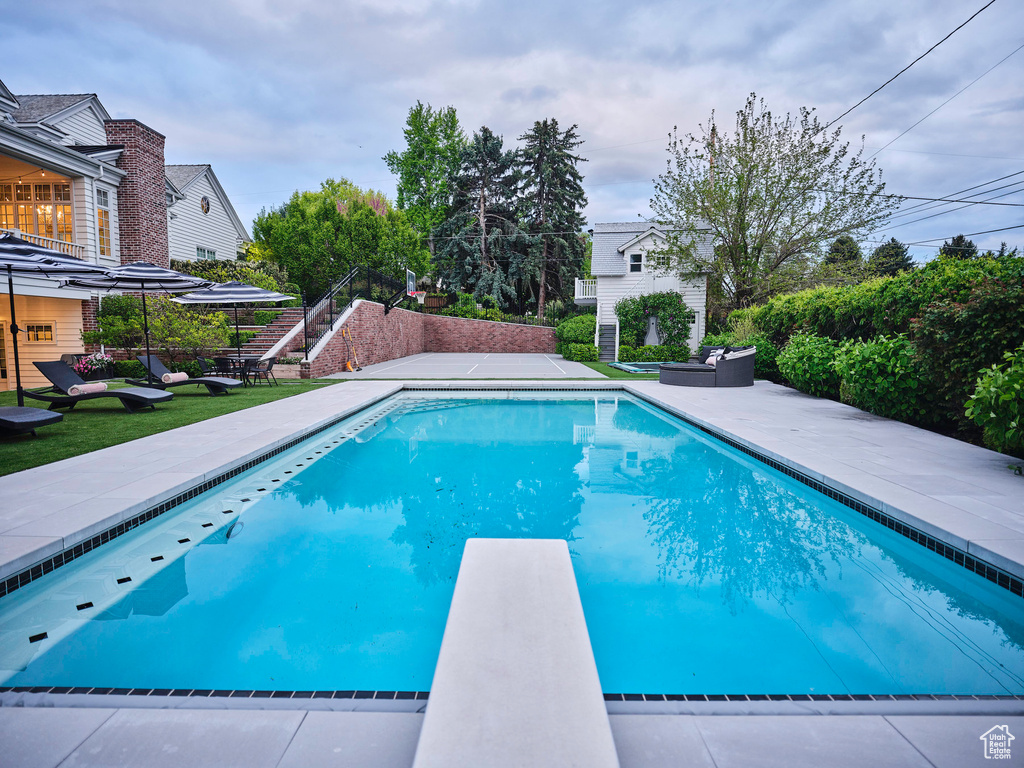 View of pool featuring a diving board and a patio