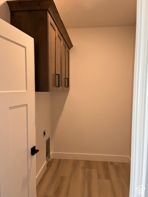 Washroom with cabinets, light hardwood / wood-style flooring, and hookup for an electric dryer