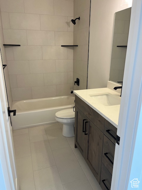 Full bathroom with vanity, tile patterned flooring, tiled shower / bath combo, and toilet