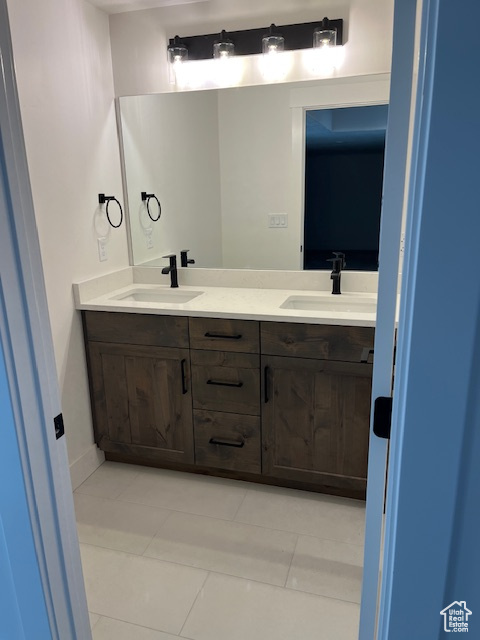 Bathroom with double sink vanity and tile patterned flooring