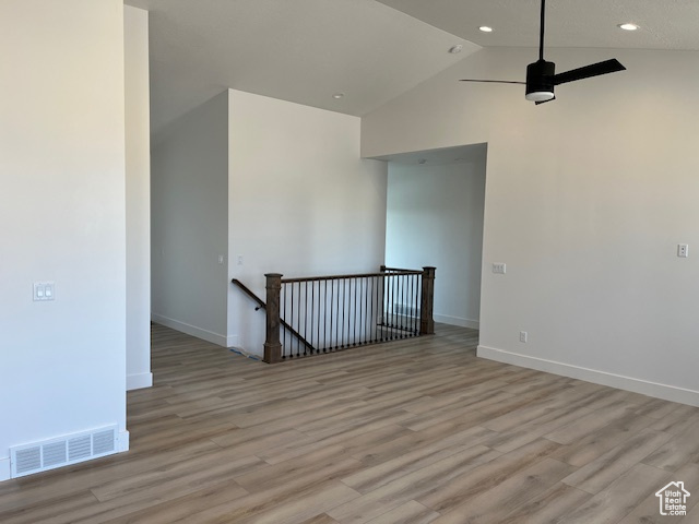 Unfurnished room with high vaulted ceiling, ceiling fan, and light wood-type flooring