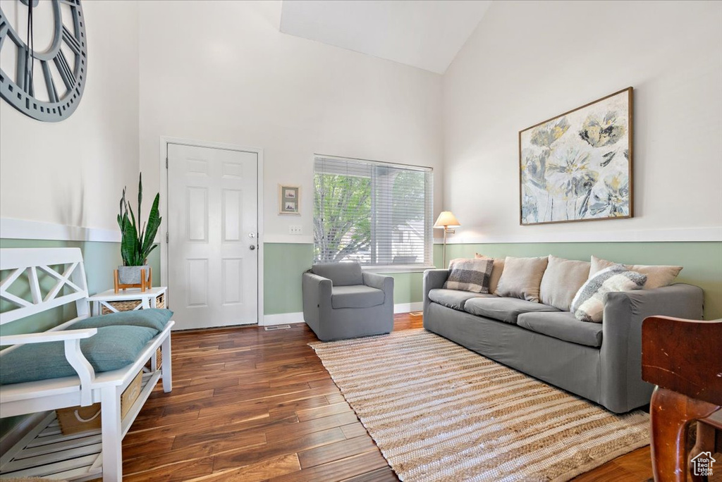 Living room featuring high vaulted ceiling and dark hardwood / wood-style floors