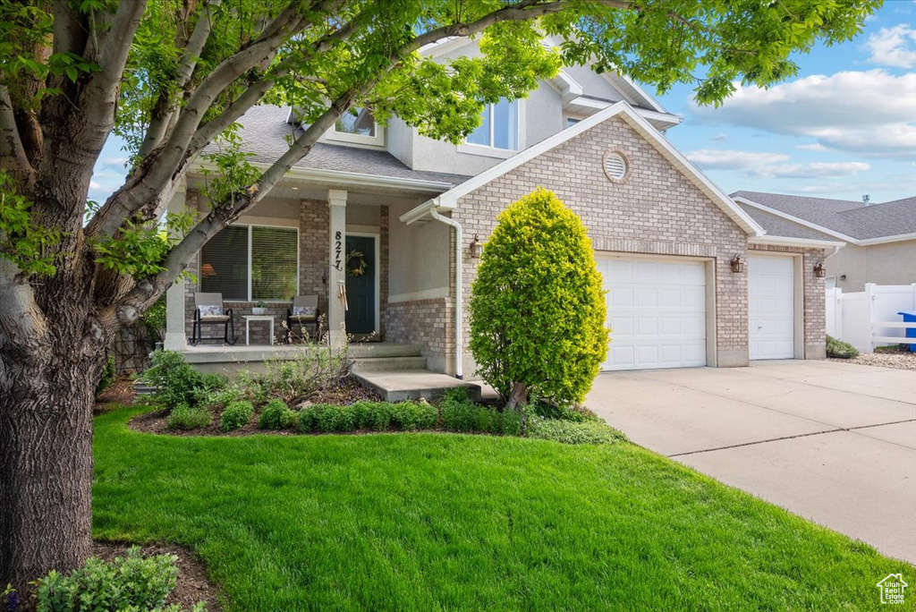 View of front of property featuring a garage and a front yard