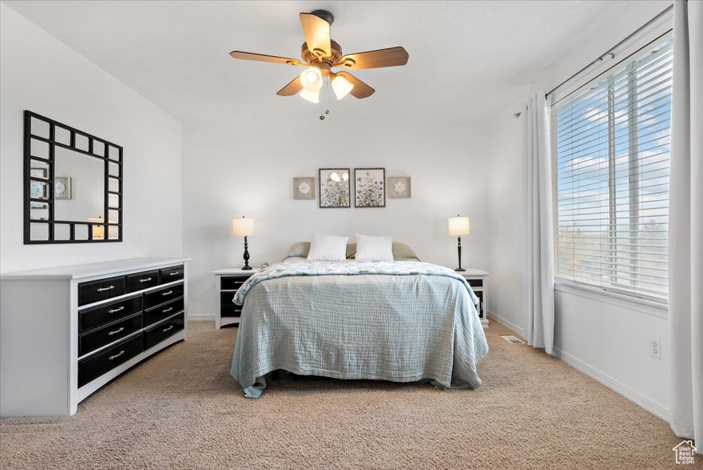 Bedroom with carpet, multiple windows, and ceiling fan