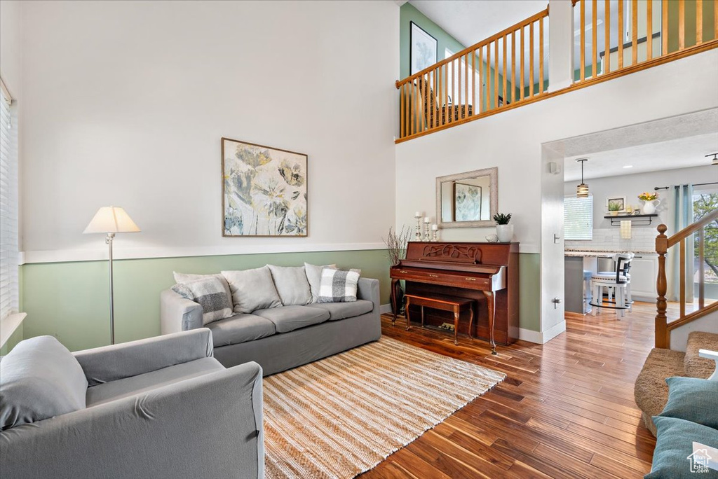 Living room with wood-type flooring and a high ceiling