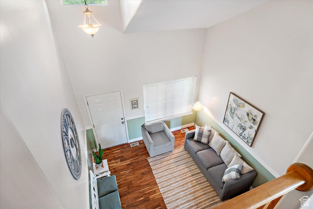 Living room with a high ceiling and hardwood / wood-style flooring