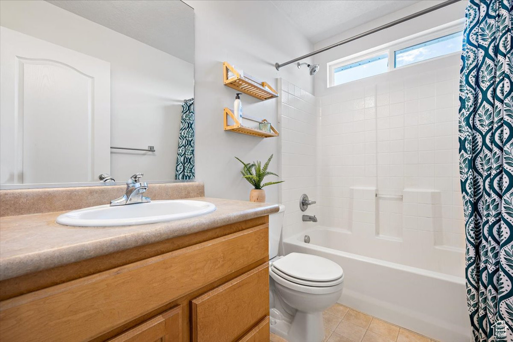 Full bathroom featuring tile flooring, shower / tub combo with curtain, vanity, and toilet