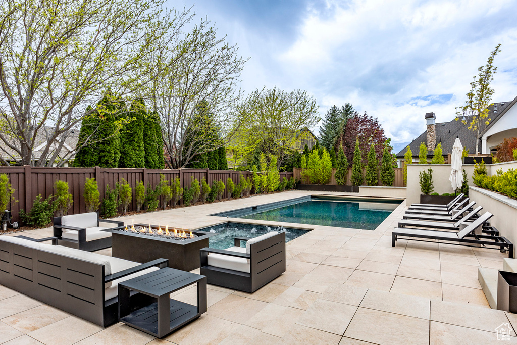 View of swimming pool featuring an outdoor fire pit and a patio area