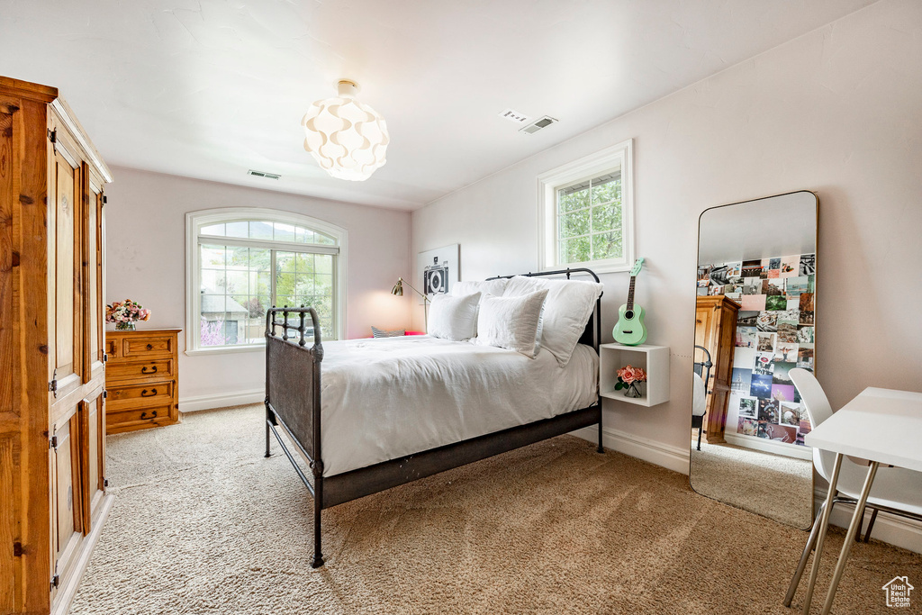 Carpeted bedroom with multiple windows