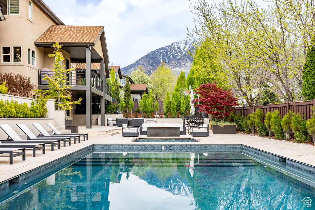 View of pool with a patio, an outdoor hangout area, and a mountain view