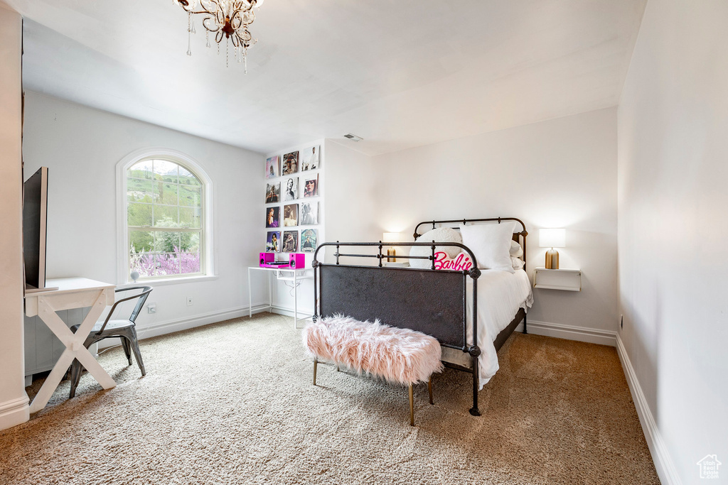 Bedroom with a chandelier and carpet floors