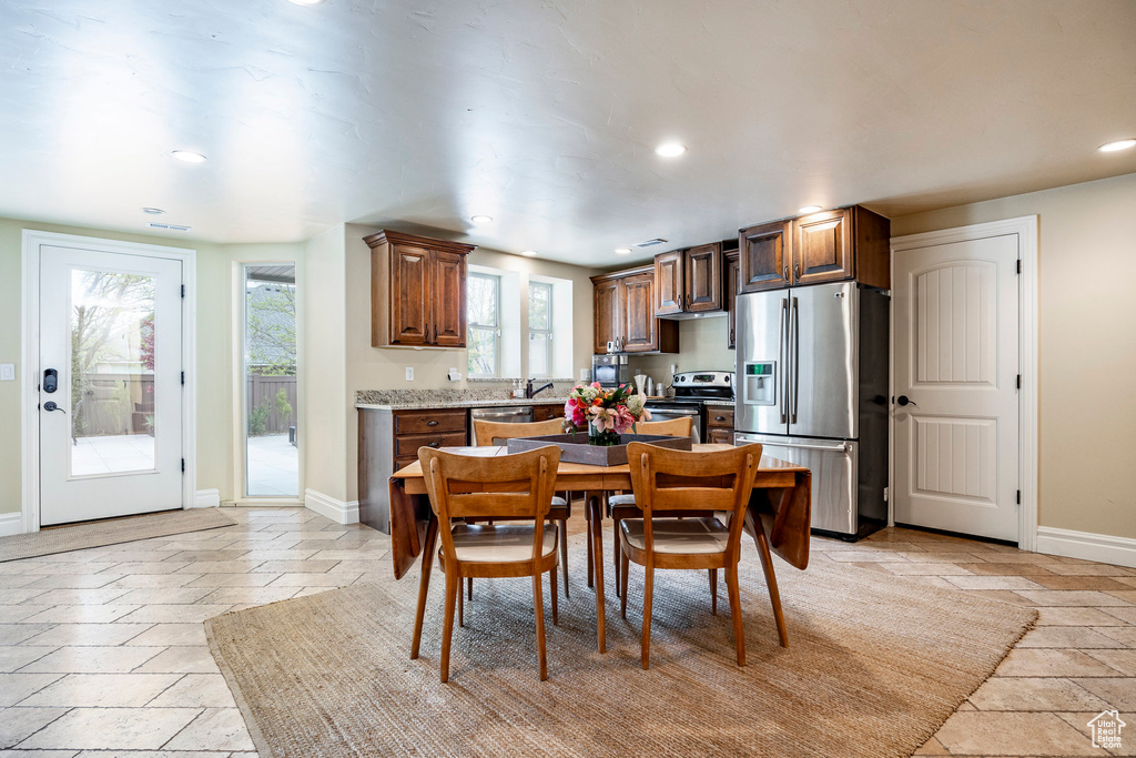 Kitchen featuring sink, light tile flooring, and appliances with stainless steel finishes